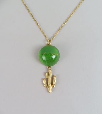 un pendentif en forme de cactus, en jade vert et or, monté sur une chaîne en or