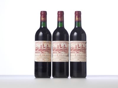 three bottles of red wine sitting on top of a white table