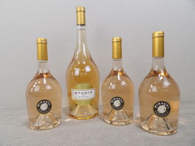 quatre bouteilles de vin sont alignées sur une table