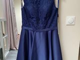 a blue dress hanging on a hanger in a room