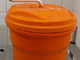 an orange bucket with a handle on top of it