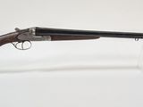 un vieux fusil posé sur un socle transparent, devant un fond blanc
