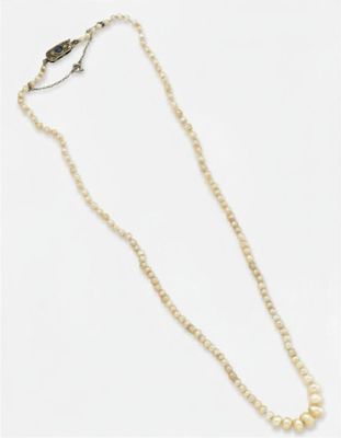 un collier de perles blanches avec un fermoir en or