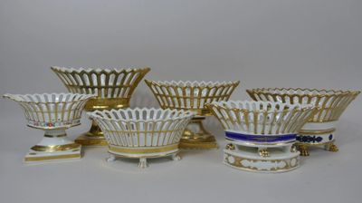 plusieurs vases blancs et dorés posés sur une table blanche