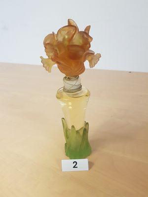 une petite bouteille contenant une fleur, posée sur une table