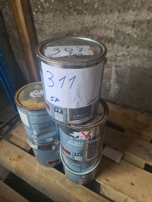 trois pots de peinture sont empilés sur une palette, accompagnés d'une étiquette de prix