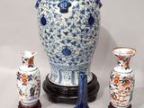 a blue and white vase sitting next to three other vases