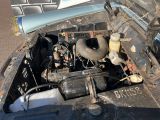 une vieille voiture dont le capot est ouvert et le moteur se trouve dans le coffre