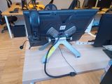 a computer monitor sitting on top of a wooden desk