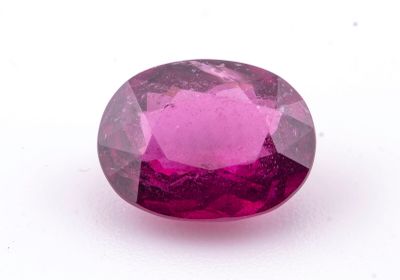 un gros plan d'un saphir rose posé sur une surface blanche