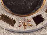 a close up of a gold and silver necklace on a table
