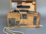 a wooden box with a phone and a cord in it