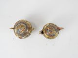 pair of small gold and silver teapots on a white surface