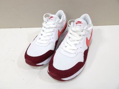 une paire de baskets blanches et rouges posées sur une surface blanche