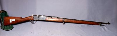 an old rifle is laying on a white surface with a green case
