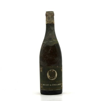 an old bottle of wine sitting on top of a white surface