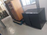 two black cabinets in a room next to a window