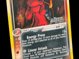 une photo d'une carte Pokémon sur laquelle figure un personnage rouge