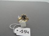 a gold ring with a black stone on it and a price tag
