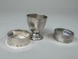 une coupe en argent et deux autres objets en argent posés sur une table