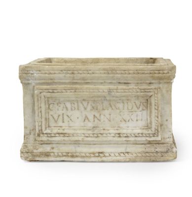 une boîte en pierre sur laquelle figurent des inscriptions sur une surface blanche