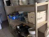 many plates and pans on a metal shelf in the kitchen