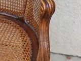 une vieille chaise peinte en marron et ornée d'un motif bleu et vert