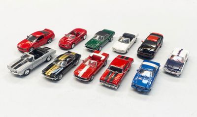several toy cars are lined up in a row on a white surface