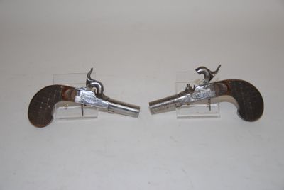 pair of antique silver plated pistols on clear acrylic bases