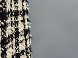 someone is holding a black and white jacket with a black and white pattern
