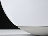 a white bowl sitting on a table with a black background