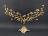 an ornate brass candelab with five candles on a stand