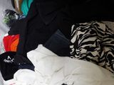 a pile of clothes in a plastic bag on a bed