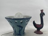 a blue vase with a bird figurine next to it