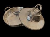pair of silver plated dishes with handles on a black background