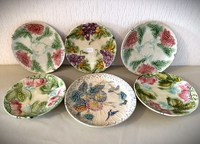 six assiettes ornées de motifs floraux, posées sur une table