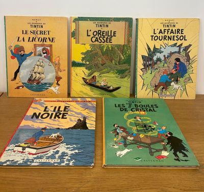 Quatre livres pour enfants sont posés sur une table devant un mur blanc