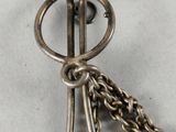 a close up of a silver pocket watch with a chain around it