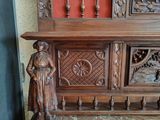 a statue of a woman standing next to a wooden cabinet