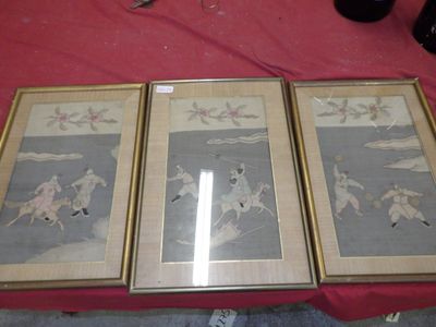 trois peintures asiatiques encadrées sur une table avec une nappe rouge