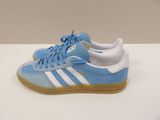 blue and white adidas sneakers with gum soles on a white surface
