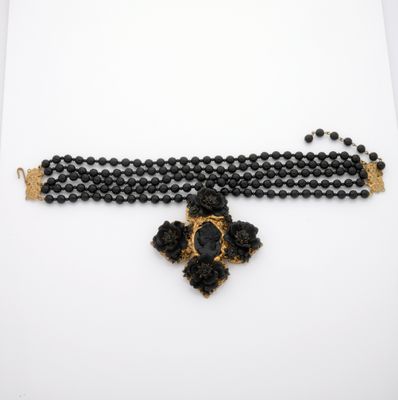 a close up of a black beaded necklace on a white surface