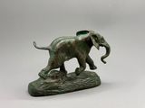 statue d'un éléphant posé sur un rocher, sur fond blanc