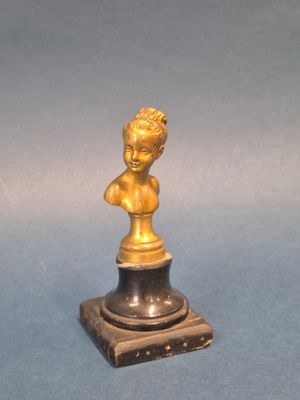 un buste en bronze représentant un garçon, posé sur un socle en marbre
