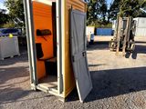 a small portable toilet sitting in the middle of a parking lot