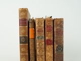 plusieurs vieux livres sont empilés sur une surface blanche