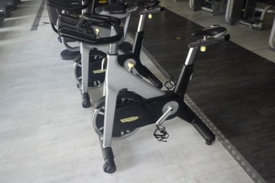 Plusieurs vélos d'appartement sont alignés en rang dans une salle de sport