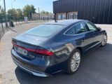 the rear end of a blue car parked in a parking lot