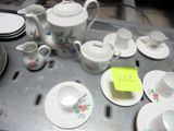 une table sur laquelle sont disposés de nombreux plats, tasses et soucoupes