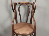 a wooden chair with a wooden seat on a grey background